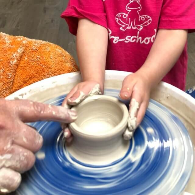 child using a clay moulding machine