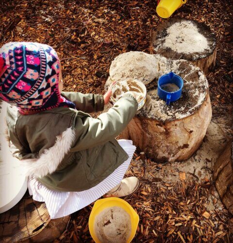 child playing with water and sand outside