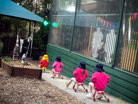 four children riding small bikes in the outdoor areas
